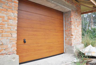 wooden garage door surrounded by brick foundation