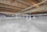 A crawl space with a plastic vapor barrier covering the ground helps protect wooden beams above from wood rot and dry rot fungus.