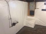 stone basement waterproofed with a wall vapor barrier and interior drainage