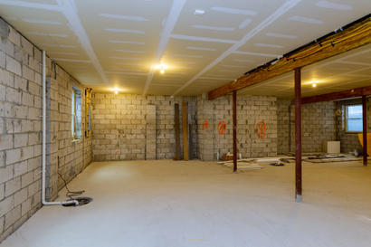 Columns in a basement with exposed concrete walls and floor.