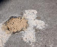 Mudjacking slurry exposed under freshly lifted concrete.