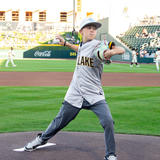 young boy throwing baseball from home plate at baseball game