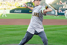 young boy throwing baseball from home plate at baseball game