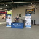 Person standing at a Groundworks booth with informational banners inside a baseball stadium