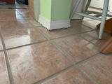 sinking interior floor with a gap between the tile floor and wooden post