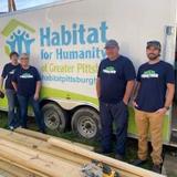 Groundworks' Pittsburgh team, formerly Baker's Waterproofing, standing next to a Habitat for Humanity truck during the Build Together 2023 initiative