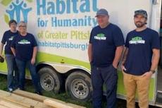 Groundworks' Pittsburgh team, formerly Baker's Waterproofing, standing next to a Habitat for Humanity truck during the Build Together 2023 initiative