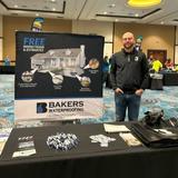 a staff member of Groundworks' Central Pennsylvania branch, formerly Baker's Waterproofing, stands at a company booth at the Wyoming Valley Run and Expo
