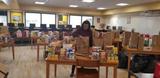 an employee from Groundworks' Pittsburgh branch, formerly Baker's Waterproofing, surrounded by donations made to the Bentworth School District
