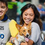 Groundworks crew member holding a Corgi dog smiling at Corgi Cup Halftime show in Seattle