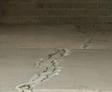 cracks in a concrete floor slab adjacent to a brick wall. this floor need floor leveling with polyurethane injection from Groundworks