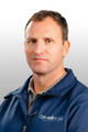 Man in blue Groundworks jacket posing for a professional headshot against a light gray background.