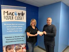 Groundworks holds a check with Macomb Forester Closet representative.