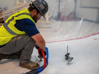 Groundworks employee performing polyurethane injection rocking slab stabilization