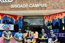 Tar Heel Basement Systems (now Groundworks Wilmington) employees holding donations made to a school supply drive for Boys & Girls Clubs of Southeastern North Carolina