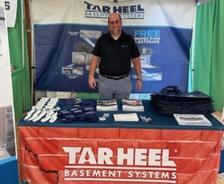 Inspector Brian Newcomb stands in the Tar Heel Basement Systems booth at the Brunswick County Agricultural Fair & Expo
