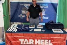 Inspector Brian Newcomb stands in the Tar Heel Basement Systems booth at the Brunswick County Agricultural Fair & Expo