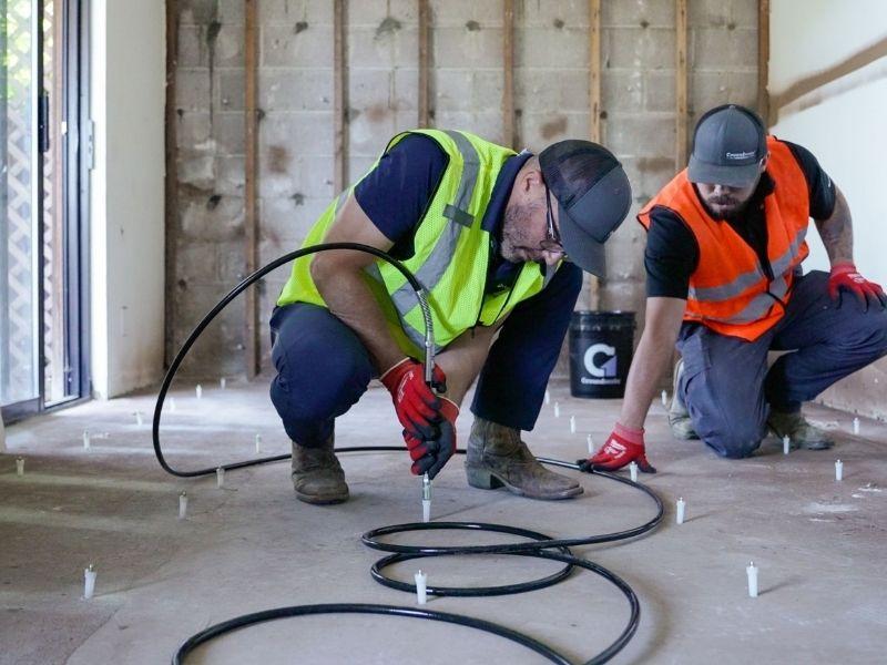 image of Groundworks employees injecting polyurethane grout curtain wall at cliff side hotel.