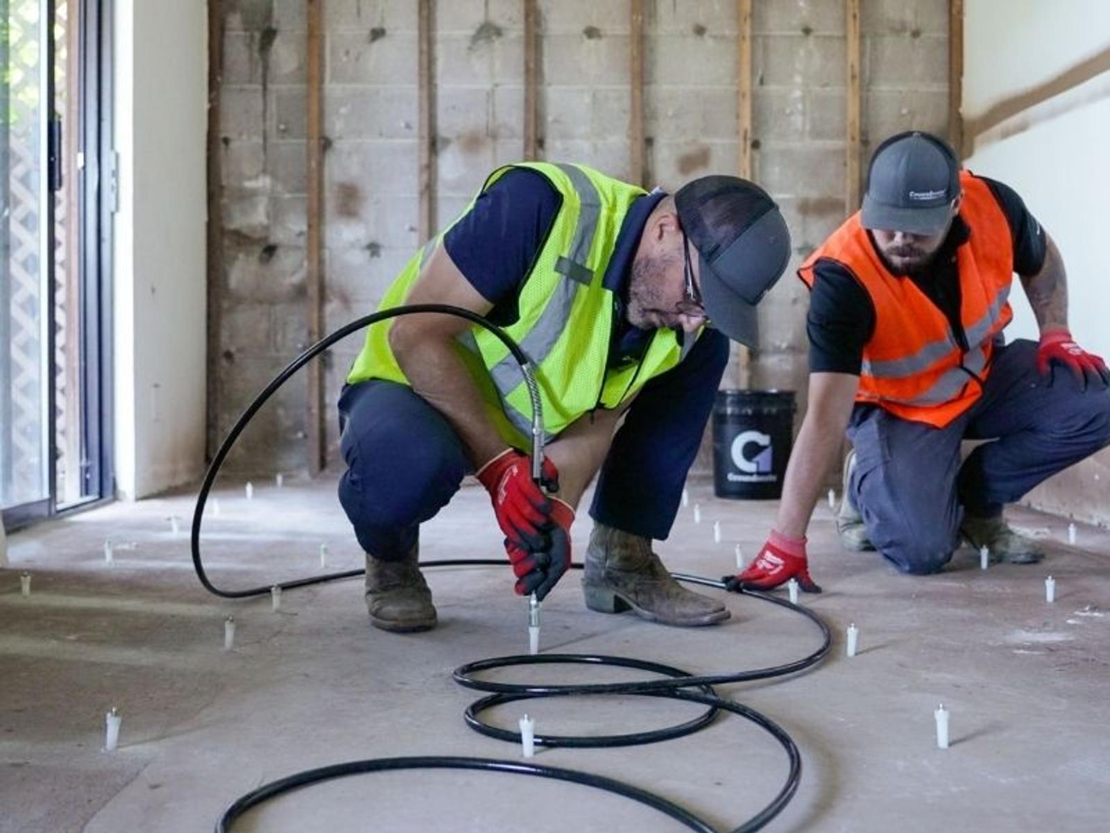 image of Groundworks employees injecting polyurethane grout curtain wall at cliff side hotel.
