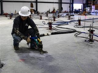 image of Groundworks employee injecting polyurethane beneath floor for floor stabilization