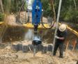 image of Groundworks employee installing helical piles to support bridge abutments