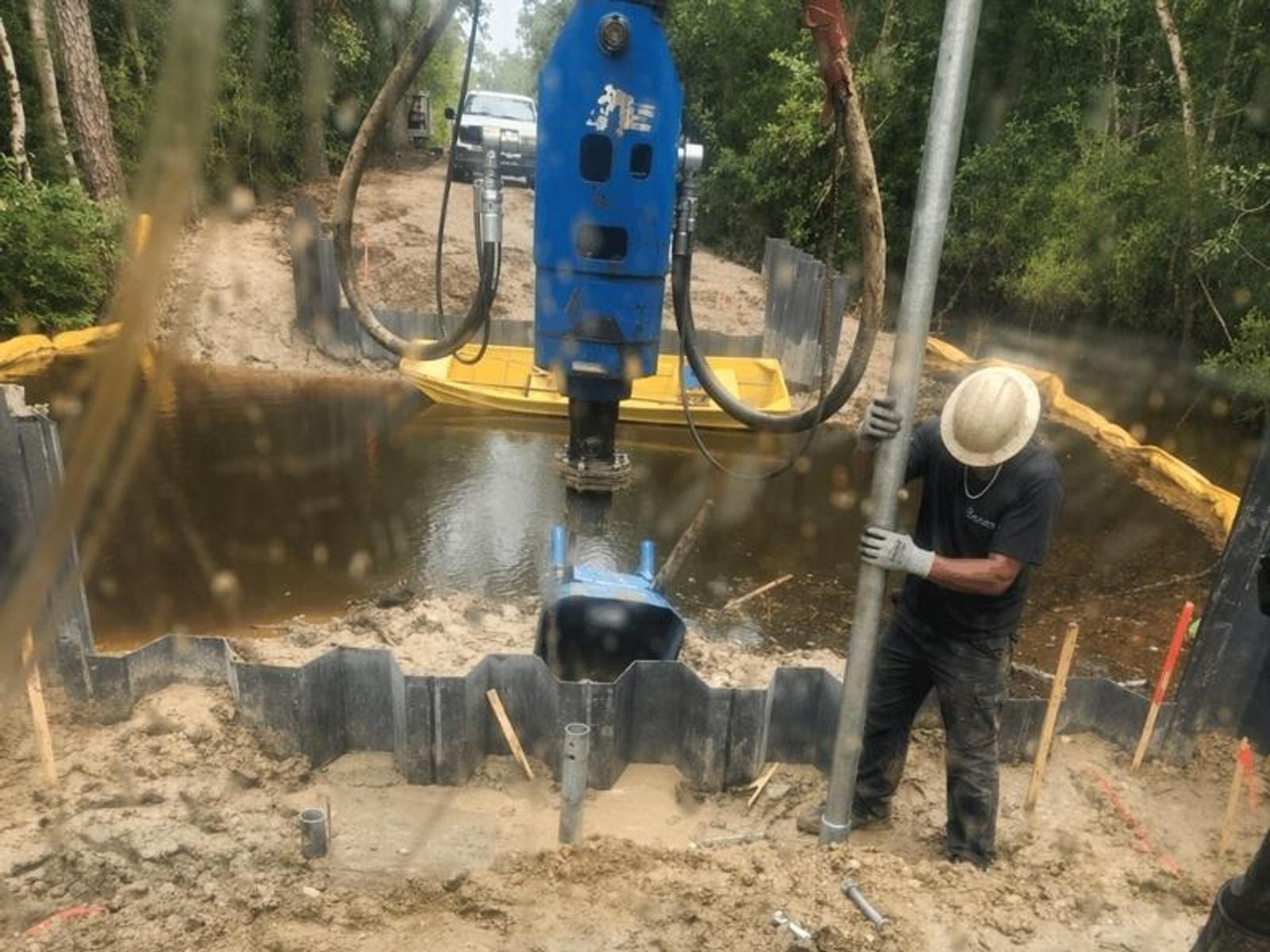 image of Groundworks employee installing helical piles to support bridge abutments