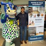A Groundworks New Haven employee with a mascot at a Hartford Yard Goats baseball game
