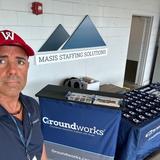 a Groundworks Boston employee stands at a company booth at a Worcester Red Sox home