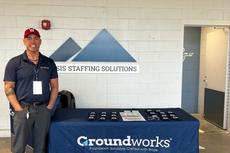 a Groundworks Boston employee stands at a company booth at a Worcester Red Sox home