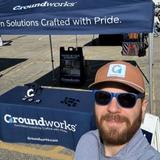 a Groundworks employee stands next to a company booth at the Roll'N Out Food Truck Festival in Grand Rapids