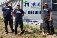 Indiana Foundation Service employees stand in front of a Habitat for Humanity of Morgan County sign for the 55th home built