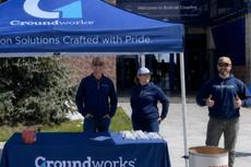 Groundworks Bozeman employees stand at a company table at the Sonny Holland Spring Game & Food Drive
