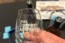 Ohio Basement Authority logo on a souvenir tasting glass from the Cleveland Cheese, Wine, and Chocolate Fest