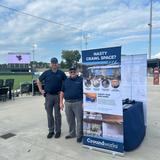 Groundworks Charlotte employees stand at a company booth at a Gastonia Ghost Peppers baseball game
