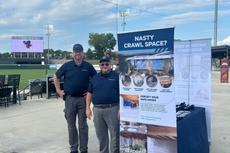 Groundworks Charlotte employees stand at a company booth at a Gastonia Ghost Peppers baseball game