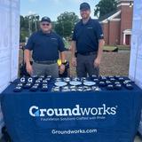 Groundworks Charlotte employees stand at a company booth at a Gastonia Ghost Peppers baseball game