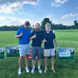 Groundworks West Virginia employees stand next to sponsorship signs at the Southern WV Home Builders Association's 8th Annual Charity Golf Outing