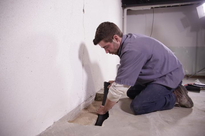 Crew installing basement draining for waterproofing