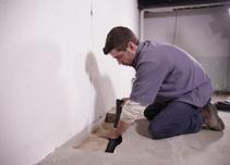 Crew installing basement draining for waterproofing