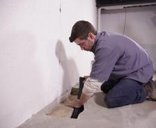 Crew installing basement draining for waterproofing