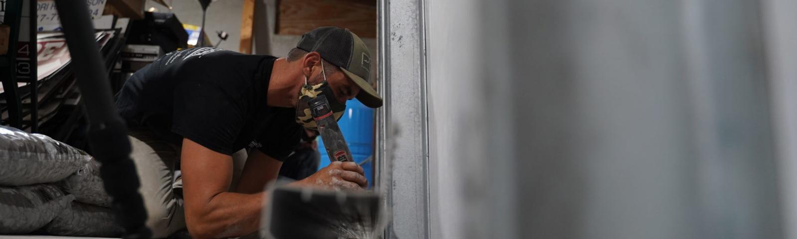 Crew installing full basment waterproofing and wall repair solution