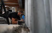 Crew installing full basment waterproofing and wall repair solution