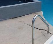 Cracked pool deck before concrete leveling