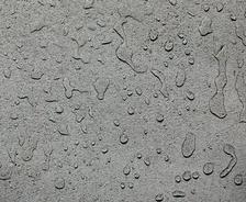Concrete surface with scattered raindrops.