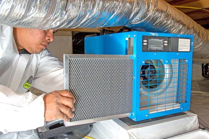 Crew installing dehumidifier in crawl space