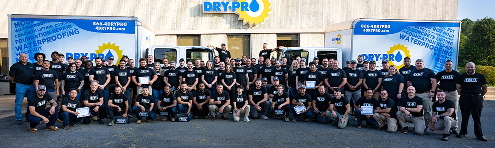 Dry Pro Foundation and Crawlspace Specialists Employees standing in front of Dry Pro Building and box trucks.
