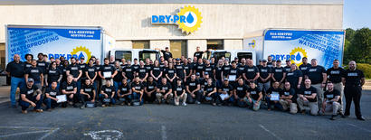 Dry Pro Foundation and Crawlspace Specialists Employees standing in front of Dry Pro Building and box trucks.