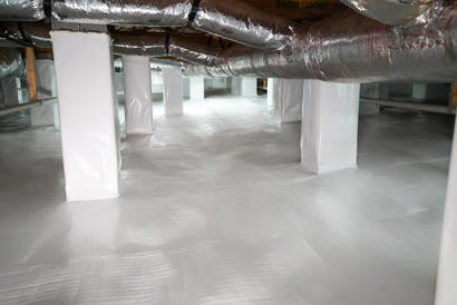 Crawl space with clean, white vapor barrier and insulated ducts running along the ceiling, showcasing how crawl space encapsulation can enhance home value.