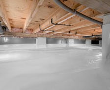 Crawl space with light wood ceiling and walls, covered in white vapor barrier material and some exposed ductwork.