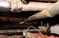Dirty crawl space with pipes and HVAC ducts